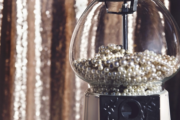Closeup shot of a clear glass pearl-shaped candy dispenser machine