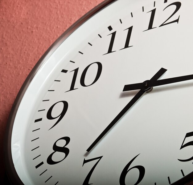 Closeup shot of a clock on a coral wall