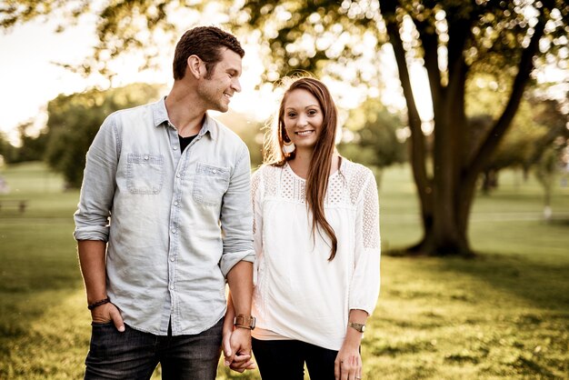 Closeup shot of a couple holding hands while smiling with a blurred background