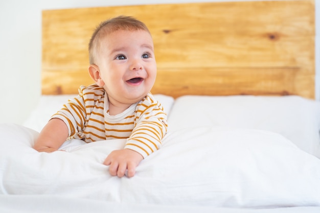 침대에 귀여운 웃는 아기의 근접 촬영 샷