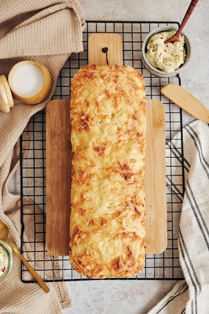 흰색 테이블에 허브 버터를 곁들인 맛있는 치즈 빵의 클로즈업 샷