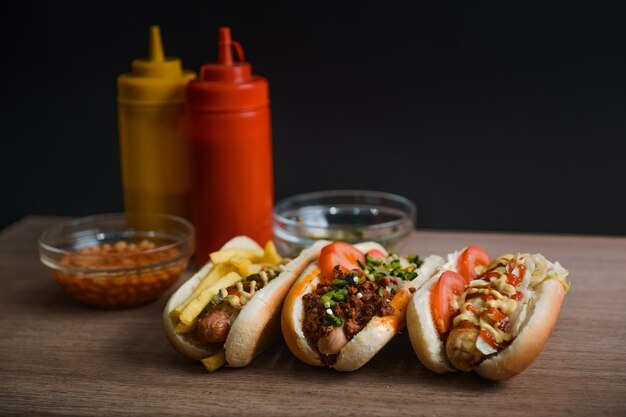 Closeup shot of delicious hot dogs with tasty dressings with sauces in the background