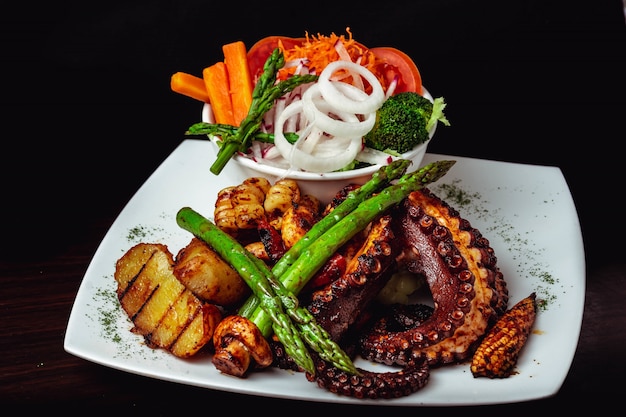 Closeup shot of a delicious roasted octopus dish with roasted asparagus and veggies