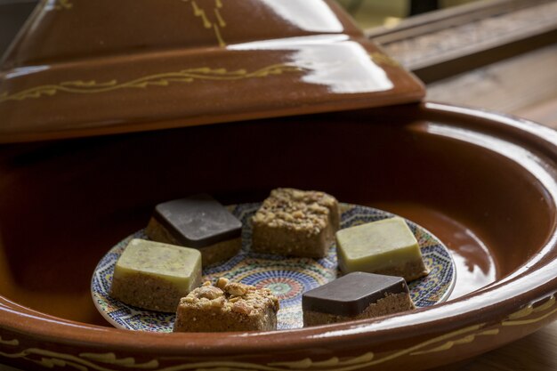 Free photo closeup shot of different types of square-shaped sweets in a wooden tray