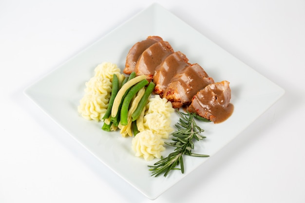 Closeup shot of a dish with mashed potatoes and meat with sauce