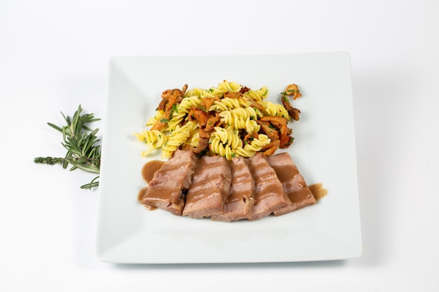 Closeup shot of a dish with pasta sauce and meat