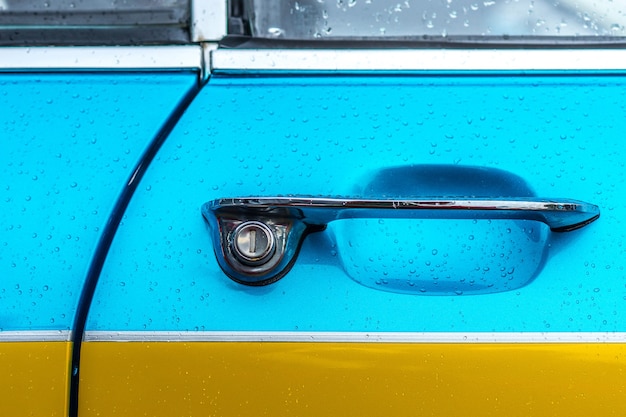 Free photo closeup shot of the door handle of a blue and yellow car