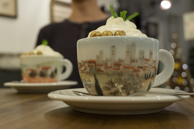 Closeup shot of a drink with whipped cream and mint leaf