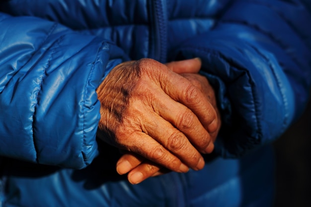 Foto gratuita colpo del primo piano delle mani rugose di una donna anziana