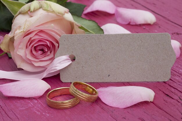 婚約指輪、タグ、テーブルの上の美しいピンクのバラのクローズアップショット