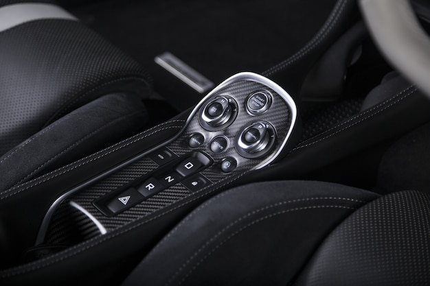 Снимок крупным планом кнопок запуска двигателя внутри современного спортивного автомобиля