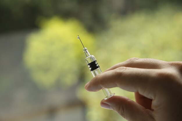 Closeup shot of a female holding a syringe