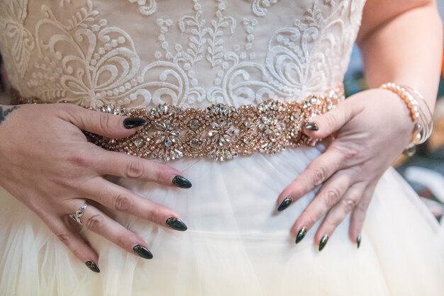Снимок крупным планом девушки, примеряющей красивое свадебное платье ручной работы