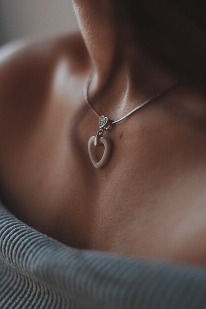 Снимок крупным планом женщины в красивом серебряном ожерелье с подвеской