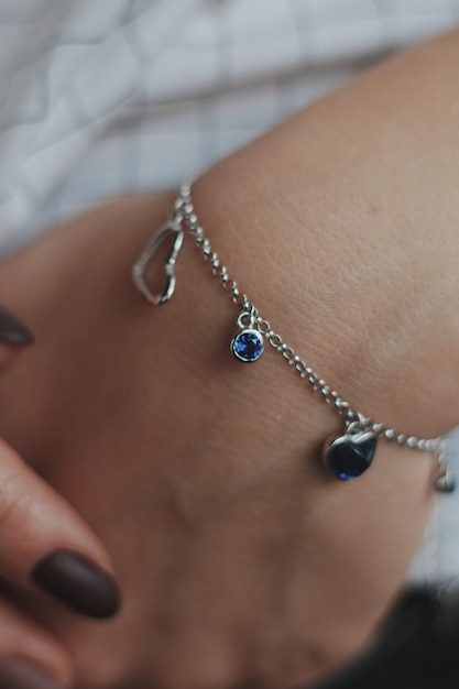 Closeup shot of a female wearing a fashionable silver charm bracelet