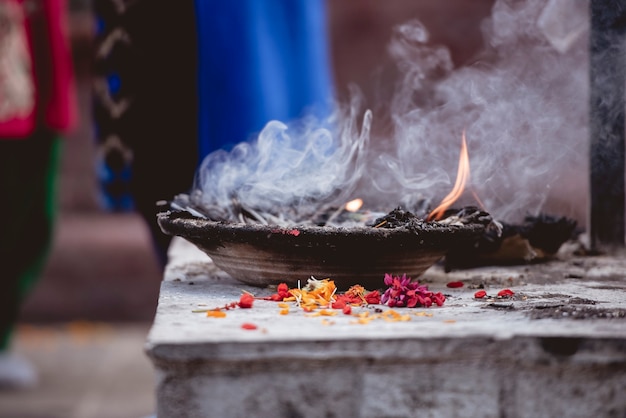 A closeup shot of flower petals burning in a metal bowl for a ceremony