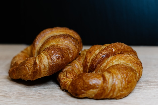 Closeup shot of fresh croissants on a wooden surface