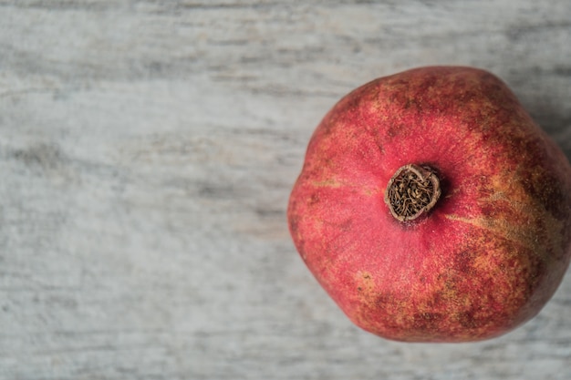 Closeup shot of a fresh ripe pomegranate on a gray background