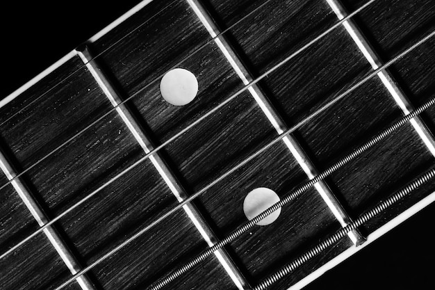 Closeup shot of fretboard of acoustic guitar isolated on black