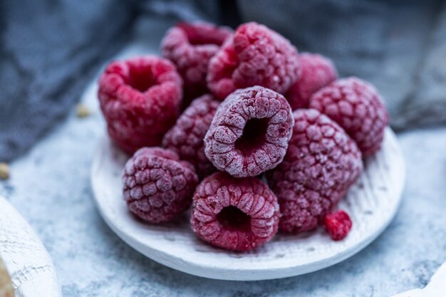 Closeup shot of frozen raspberries in a plate on the table