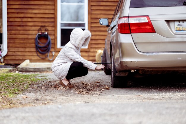 Closeup shot of a girl repairing a car wheel