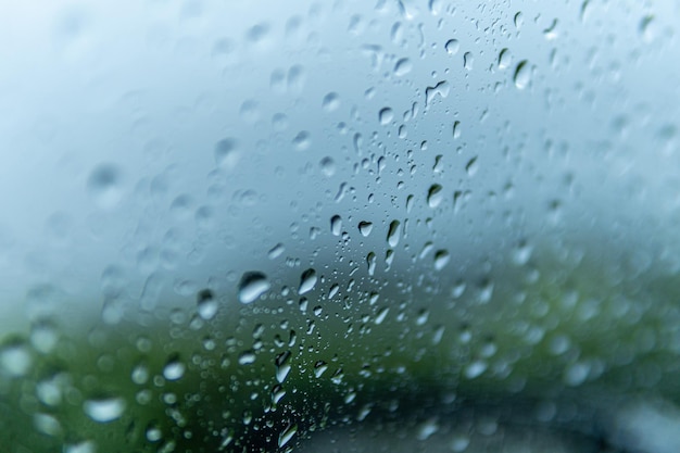 Снимок крупным планом стекла окна, покрытого каплями дождя - для фона и текстур