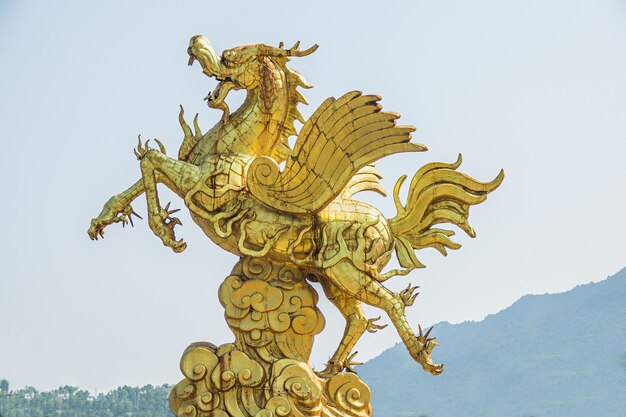 Closeup shot of a gold statue of a unicorn during daytime