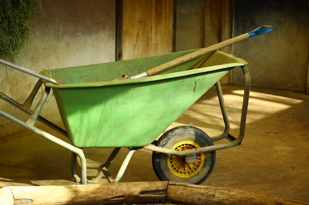 Colpo del primo piano di una carriola verde in una stanza