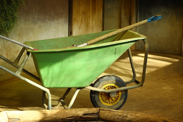 Closeup shot of a green wheelbarrow in a room