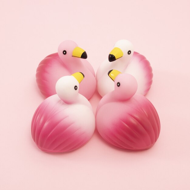 Closeup shot of a group of identical rubber flamingos facing each other