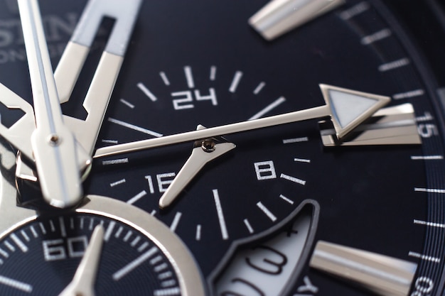 Closeup shot of the hands, numbers and hour marks of a black watch