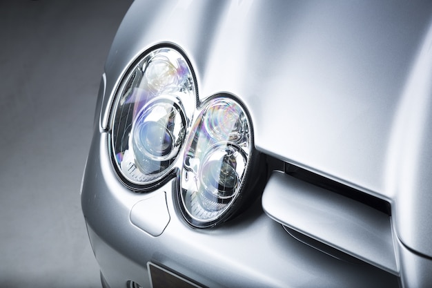 Closeup shot of a headlight of a silver car