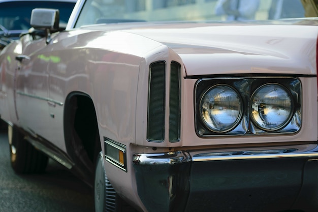 Closeup shot of the headlights of a beige antique car