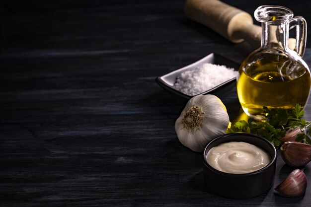 Closeup shot of ingredients like olive oil, salt, garlic, herbs, sauce