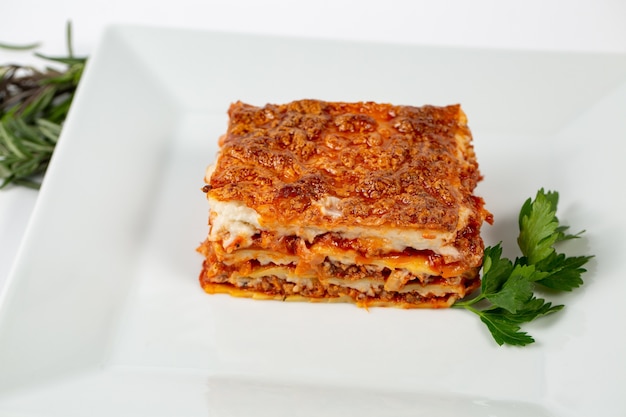Closeup shot of lasagna on a white plate