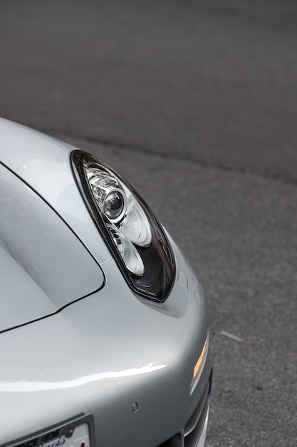 Closeup shot of the left headlight of white sports car