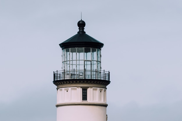 Free photo closeup shot of a lighthouse with a blue cloudy sky