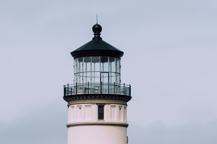 Free Photo closeup shot of a lighthouse with a blue cloudy sky