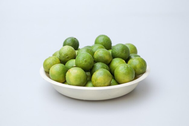 Closeup shot of limes in a plate on a white surface