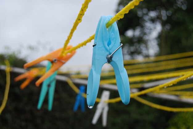 Closeup shot of a lot of colorful clothespins on yellow cables