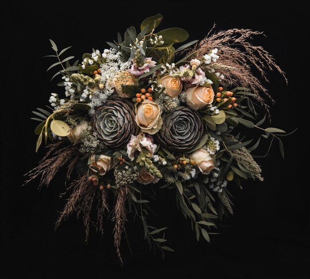 Closeup shot of a luxurious bouquet of orange and brown roses on a black wall