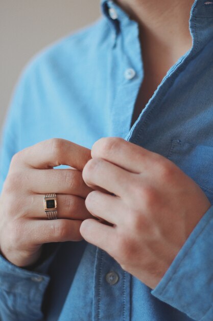 Closeup shot of a male in a formal outfit wearing a golden ring