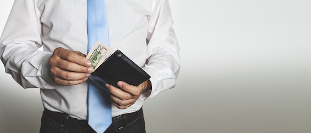 Closeup shot of male hands holding an open leather wallet with money - concept of finance success