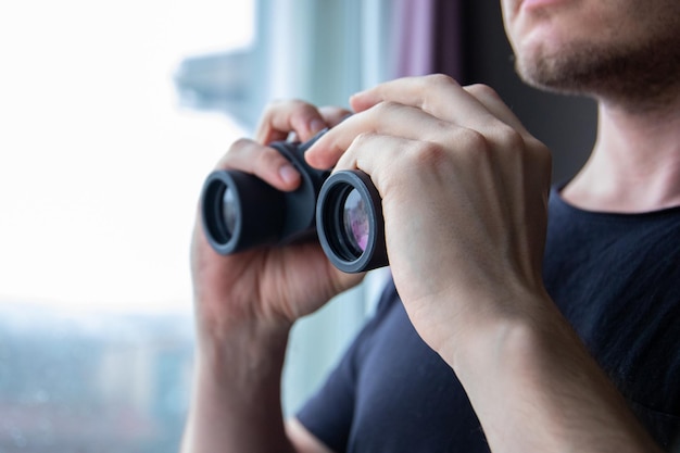 Closeup shot of a male holding binoculars