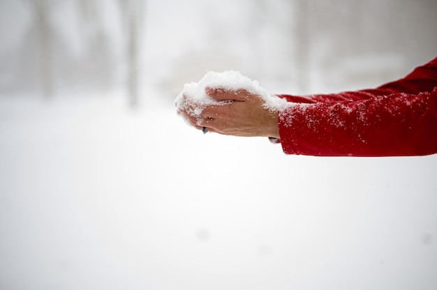 彼の手のひらで雪を保持している男性のクローズアップショット