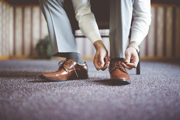 彼の靴を結ぶと、ビジネス会議の準備をしている男性のクローズアップショット