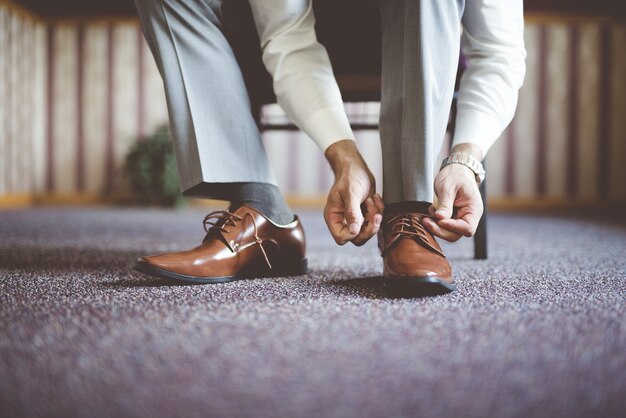 Closeup shot of a male tying his shoes and getting ready for a business meeting