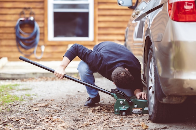 Free photo closeup shot of a man repairing a car with a tool