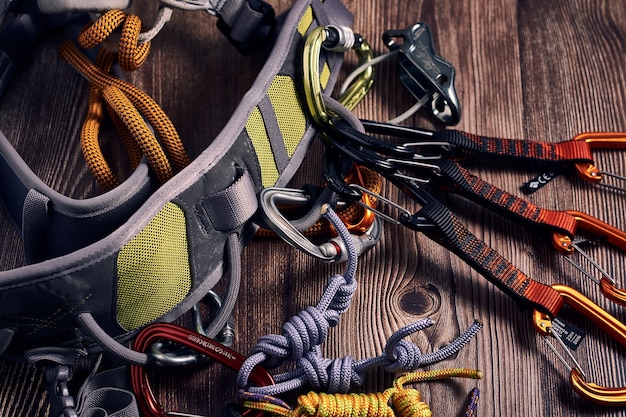 Closeup shot of many colorful climbing carabiners and knots on a wooden surface