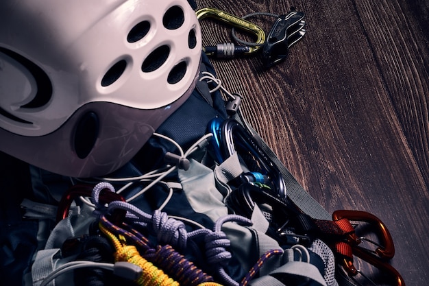 Closeup shot of many colorful climbing carabiners and knots on a wooden surface